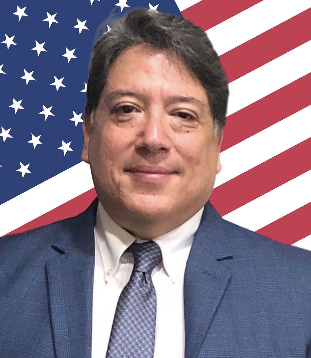 Mario Reyes in front of an American flag